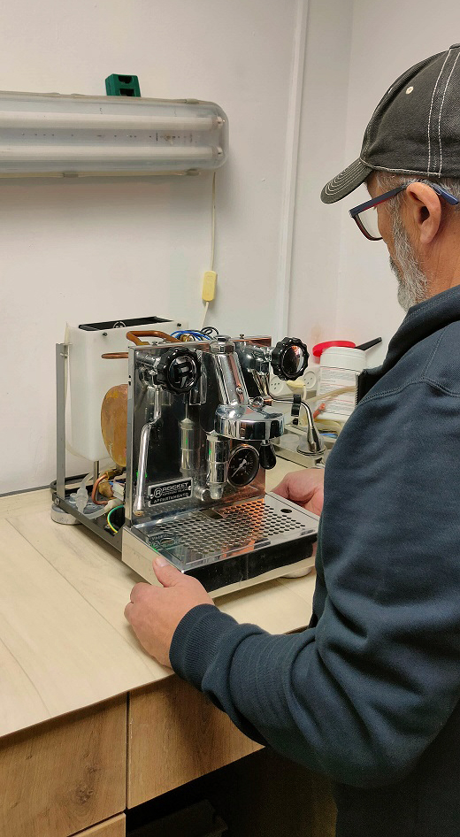 תיקון מכונות קפה טכנאי עובד במעבדת מכונות קפה